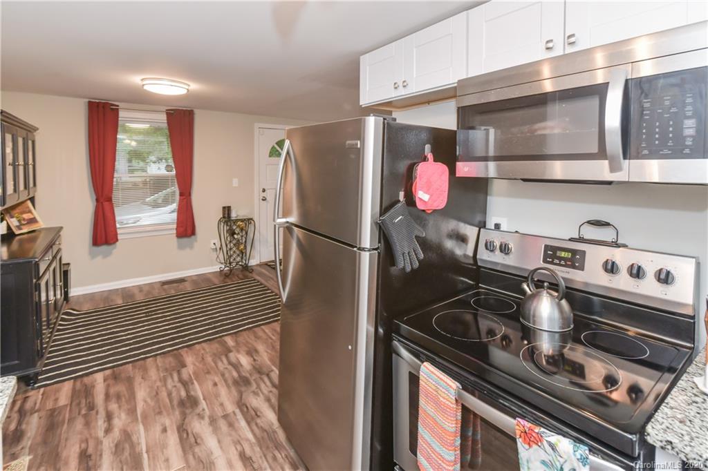 1239 Log Cabin Road Charlotte, NC 28213 - Photo 8 of 26 a kitchen with a stove and a wooden floor