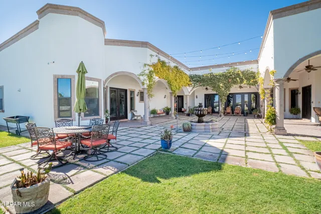 a view of a patio with couches table and chairs with wooden floor and fence