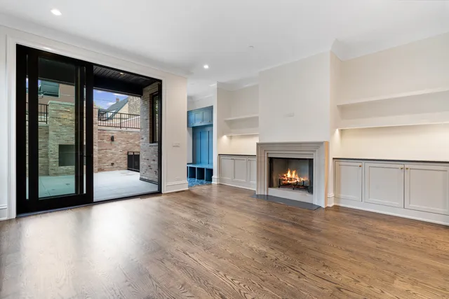 a view of an empty room with wooden floor and windows