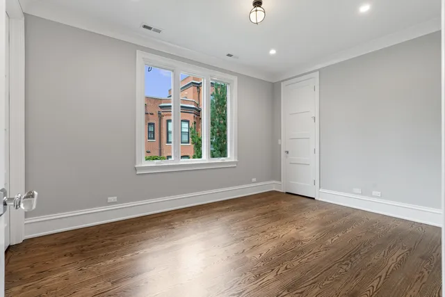 a view of empty room with wooden floor and windows