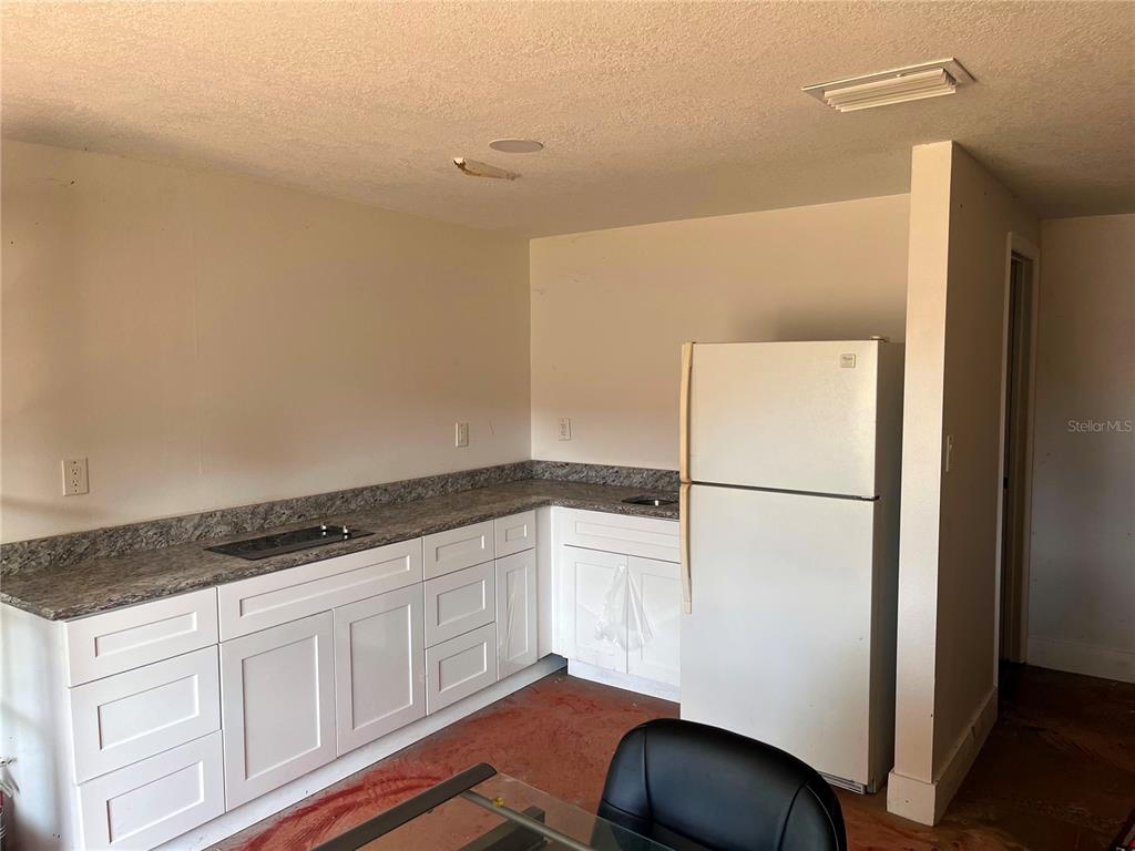 4795 Highway 1 Mims, FL 32754 - Photo 12 of 22 a kitchen with a refrigerator and white cabinets