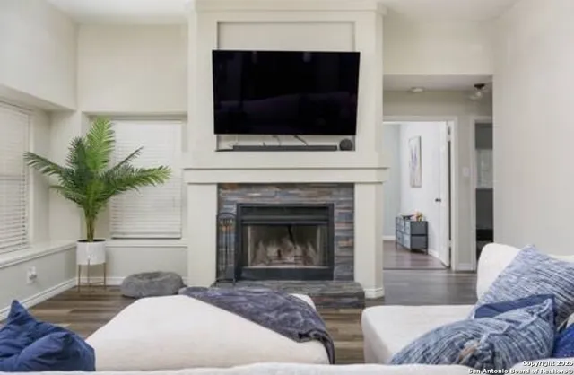 a living room with furniture a fireplace and a flat screen tv