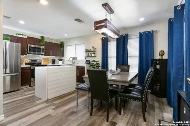 a kitchen with a table chairs refrigerator and microwave