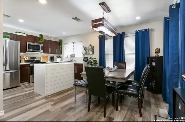 a kitchen with a table chairs refrigerator and microwave