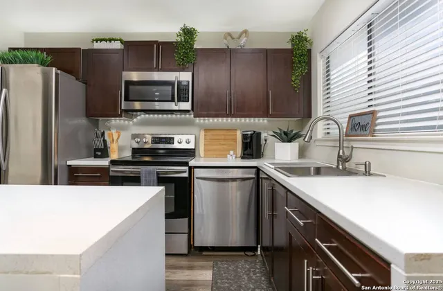 a kitchen with a sink a microwave a refrigerator and cabinets