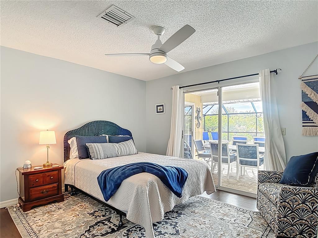 10253 Winstead Avenue Englewood, FL 34224 - Photo 15 of 46 a bedroom with a large bed and wooden floor