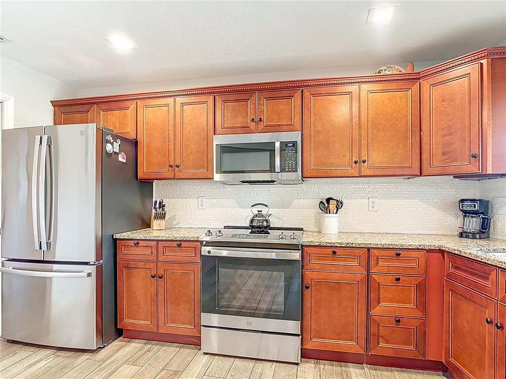 10253 Winstead Avenue Englewood, FL 34224 - Photo 24 of 46 a kitchen with stainless steel appliances granite countertop a refrigerator sink and cabinets