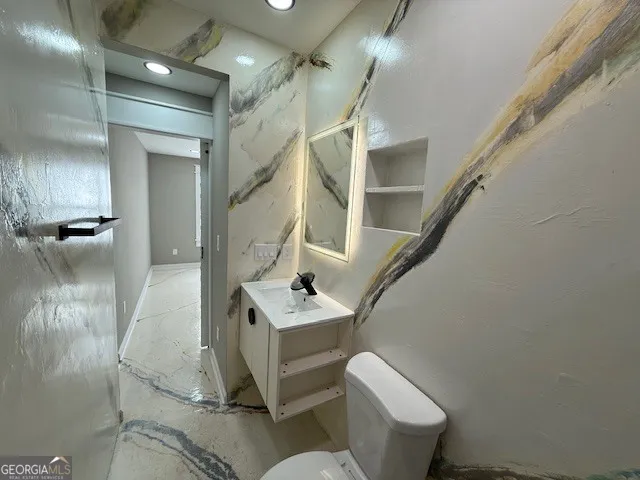 a bathroom with a sink mirror vanity and toilet