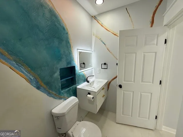 a bathroom with a toilet sink and mirror