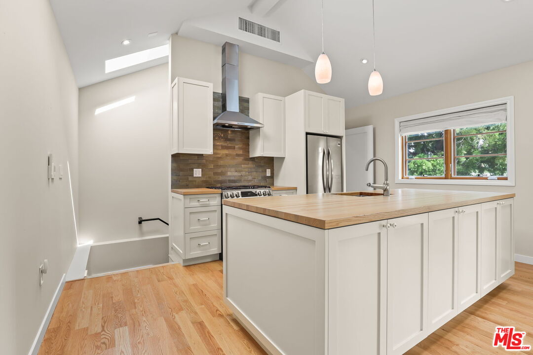652 Kensington Road, Unit B Santa Monica, CA 90405 - Photo 5 of 15 a kitchen with kitchen island granite countertop a stove and a sink