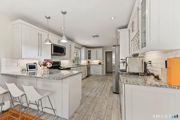 a kitchen with granite countertop a sink appliances and cabinets