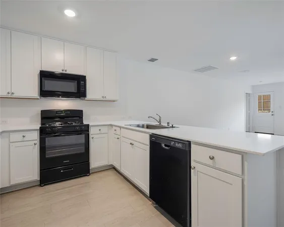 a kitchen with granite countertop a sink and stainless steel appliances