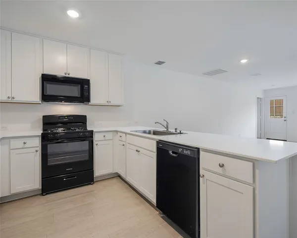 a kitchen with granite countertop a sink and stainless steel appliances