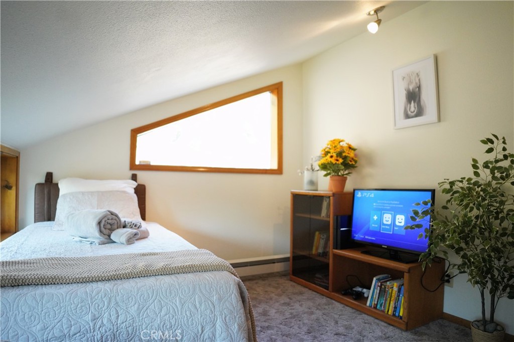 40659 Indian Springs Road Oakhurst, CA 93644 - Photo 17 of 28 a bedroom with a bed a potted plant and a window