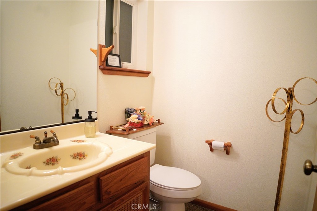 40659 Indian Springs Road Oakhurst, CA 93644 - Photo 21 of 28 a bathroom with a sink and mirror with toilet