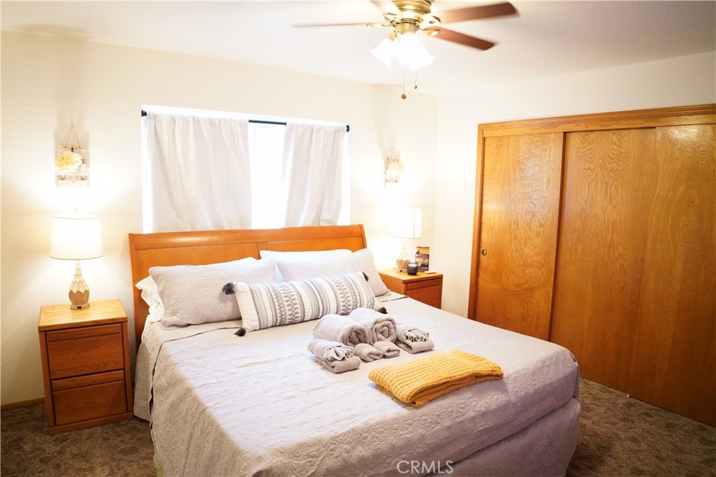 40659 Indian Springs Road Oakhurst, CA 93644 - Photo 22 of 28 a bedroom with a bed and a chandelier