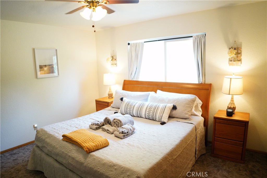40659 Indian Springs Road Oakhurst, CA 93644 - Photo 23 of 28 a bedroom with a bed and a chandelier