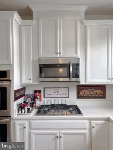 a kitchen with stainless steel appliances granite countertop a sink and a stove top oven