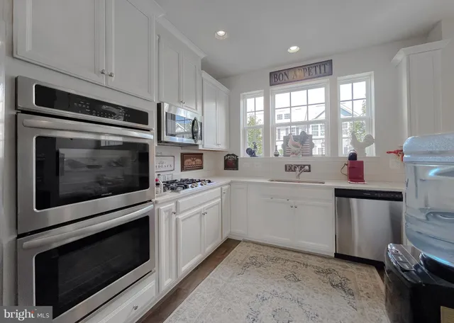 a kitchen with sink a microwave and cabinets