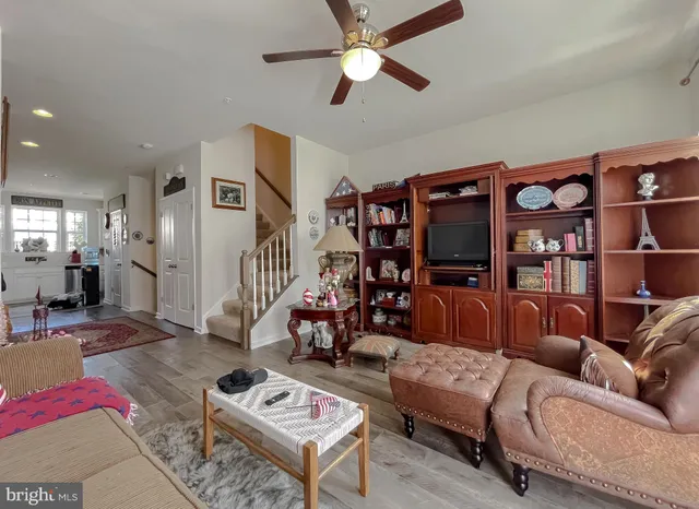 a living room with furniture a ceiling fan and a rug
