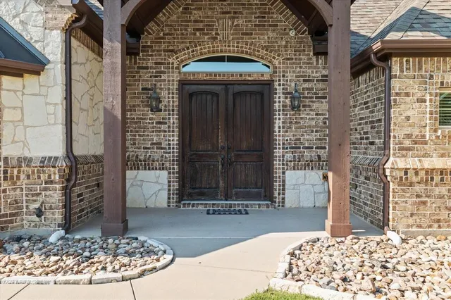 a kitchen with stainless steel appliances kitchen island granite countertop a table chairs sink and cabinets