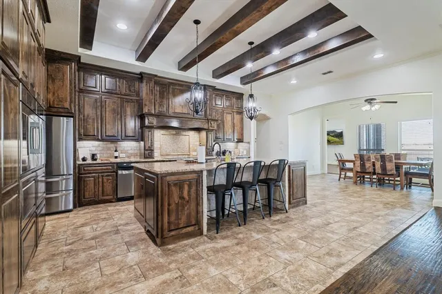 a kitchen with kitchen island granite countertop a table chairs stove and cabinets