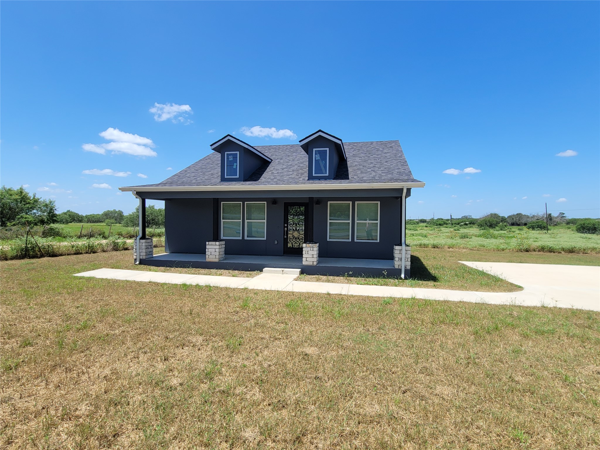A charming single-family home awaits, set amidst a generous lot with a broad concrete driveway.