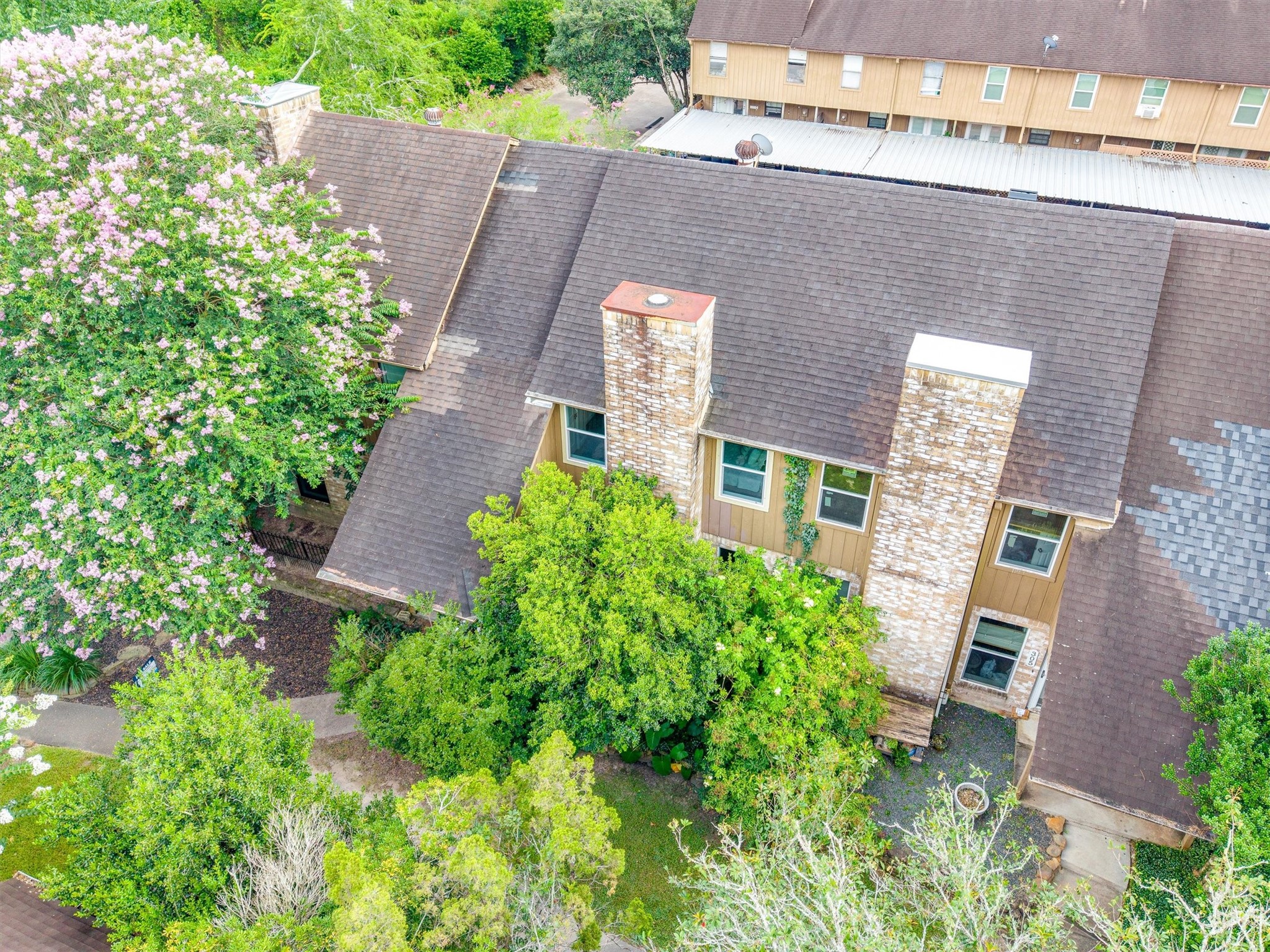 1011 Hamblen Road, Unit 306 Houston, TX 77339 - Photo 29 of 38 From above, the home's brick chimneys and rooftop lines come into view, tucked beneath a canopy of mature trees that gives the whole property a private, secluded feel.