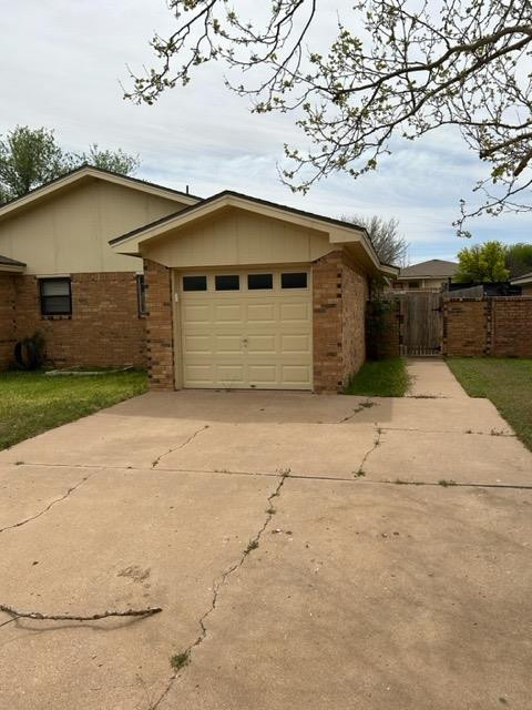 6111 38th Street, Unit B Lubbock, TX 79407 - Photo 2 of 9 a front view of a house with a yard