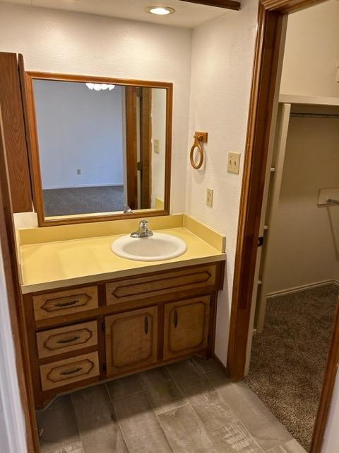 6111 38th Street, Unit B Lubbock, TX 79407 - Photo 8 of 9 a bathroom with a sink a vanity and a mirror