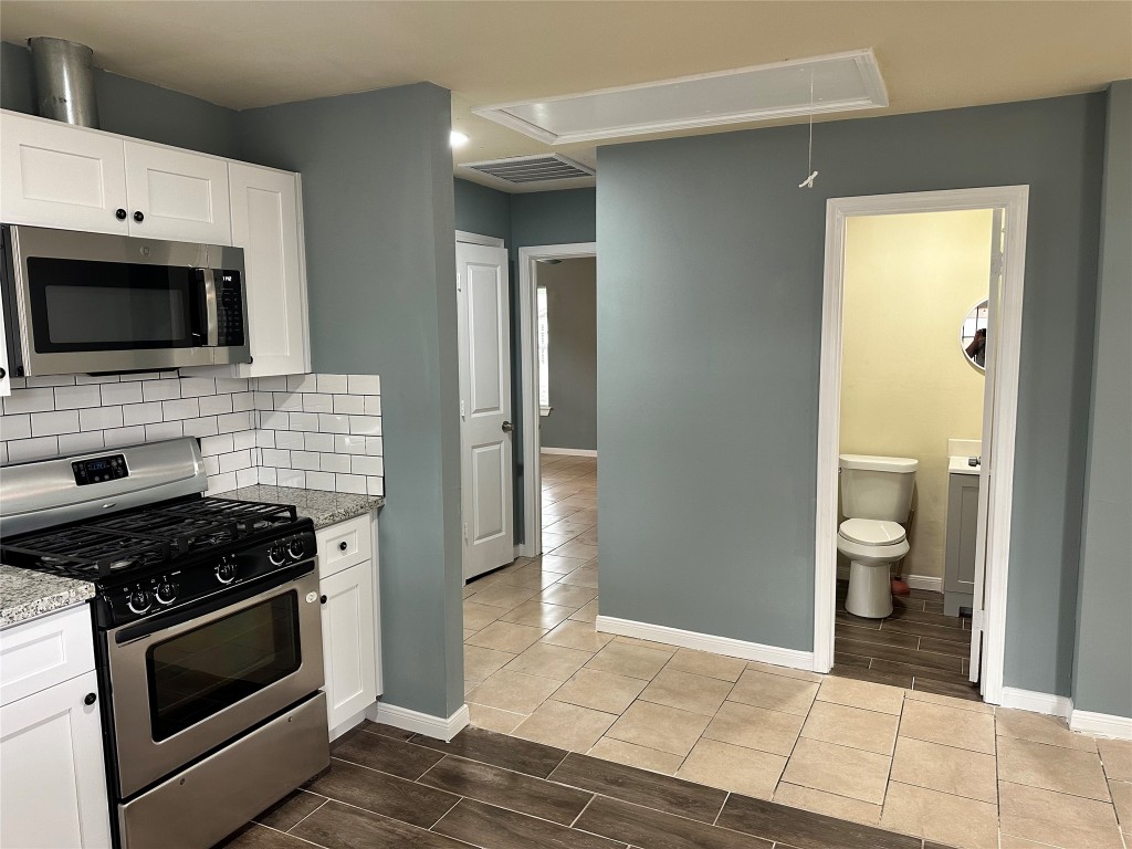 6911 Bauman Road Houston, TX 77022 - Photo 8 of 17 a kitchen with a stove and a microwave