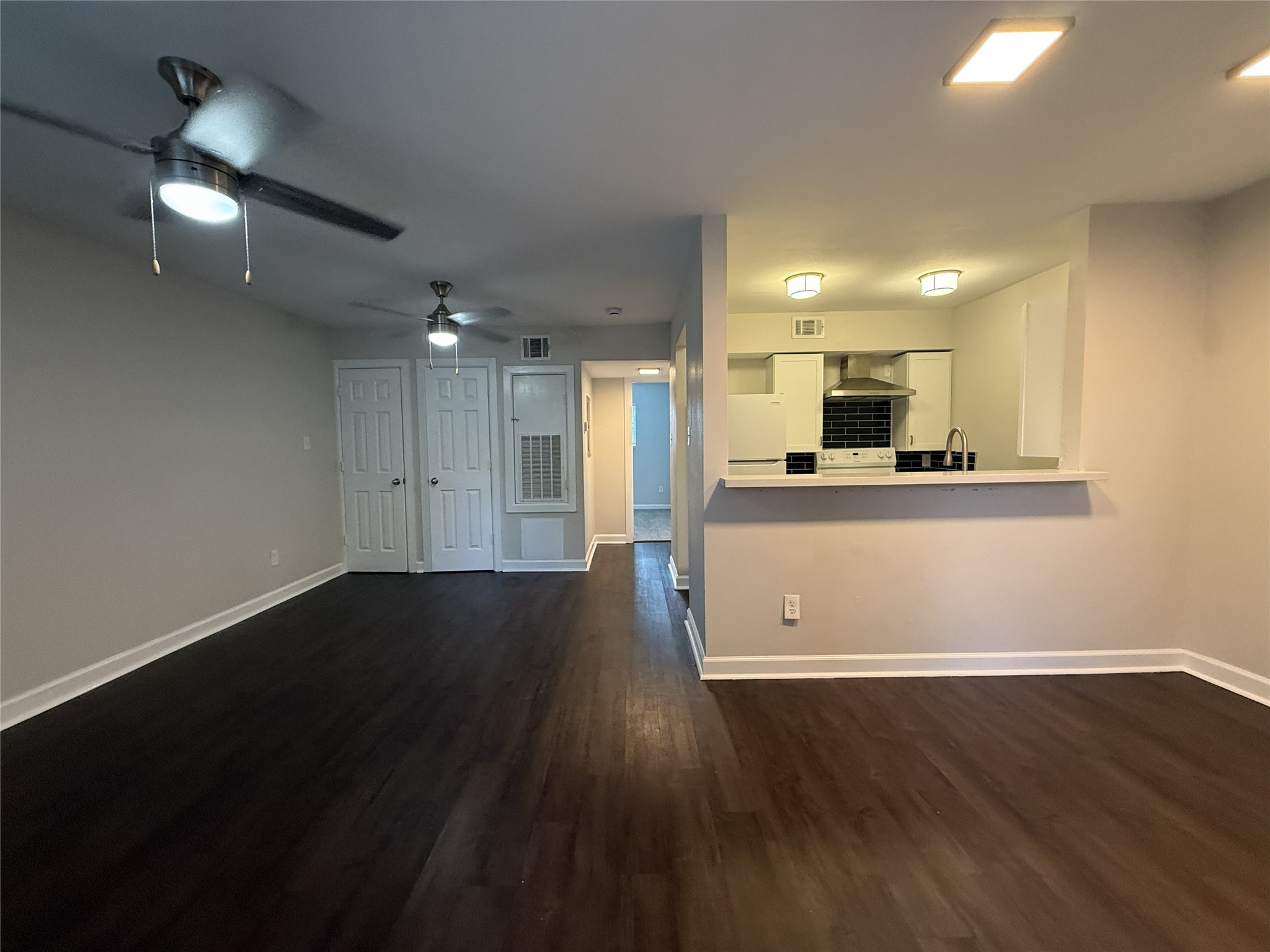 wooden floor in an empty room with a kitchen