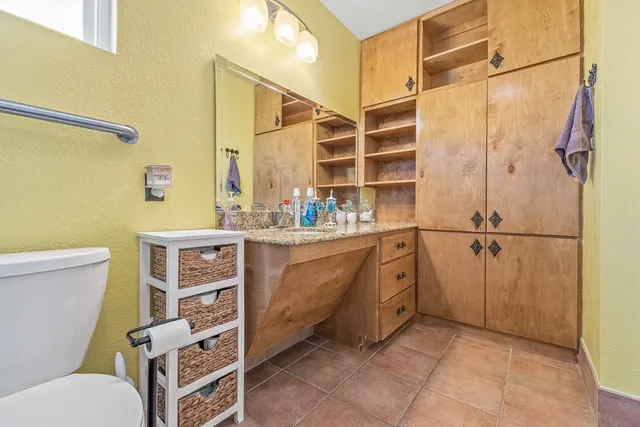 a bathroom with a granite countertop sink toilet and shower