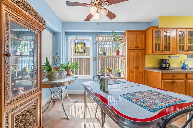 a dining room with furniture a rug a potted plant and a chandelier