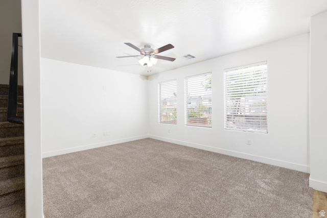 3157 Deseret Drive St. George, UT 84790 - Photo 7 of 24 Spacious interior room featuring light-toned carpeting, white walls, and a ceiling fan with integrated lighting