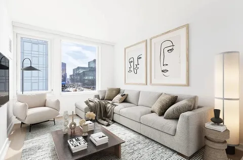 a living room with furniture and a large window with garden view