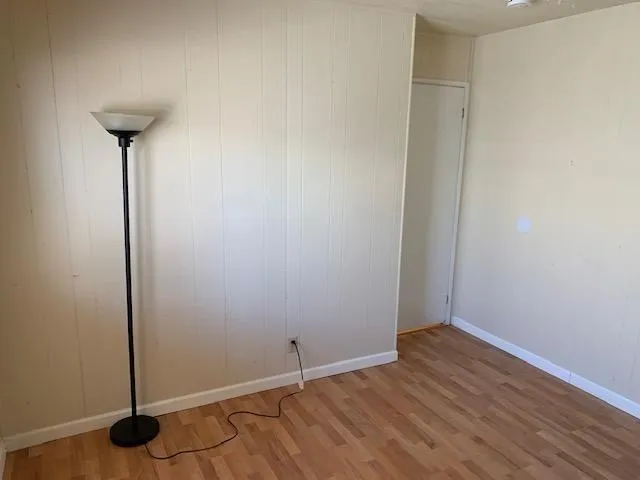 a view of a room with wooden floor and a table