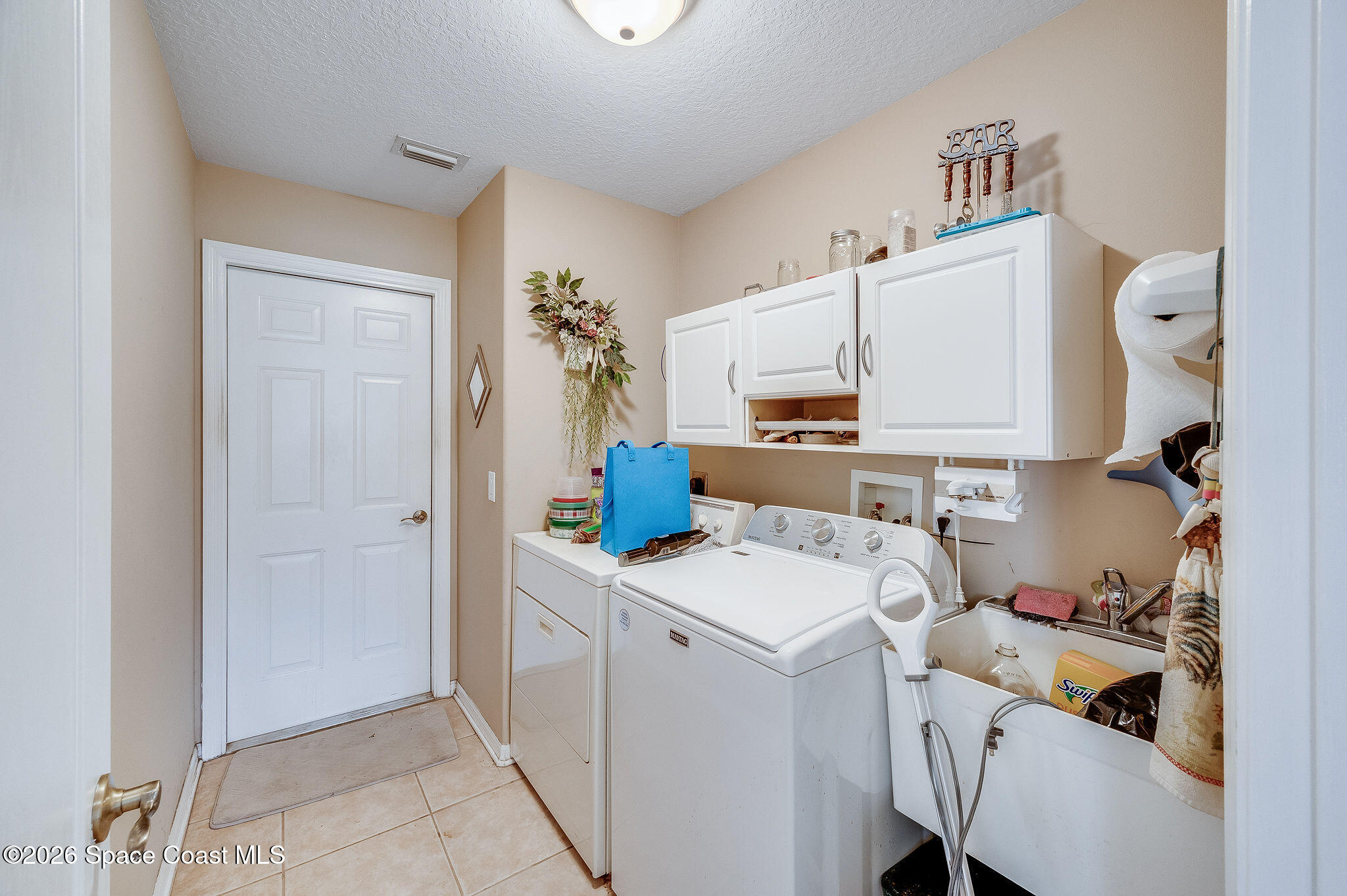 4910 Worthington Circle Rockledge, FL 32955 - Photo 28 of 69 a utility room with cabinets washer and dryer