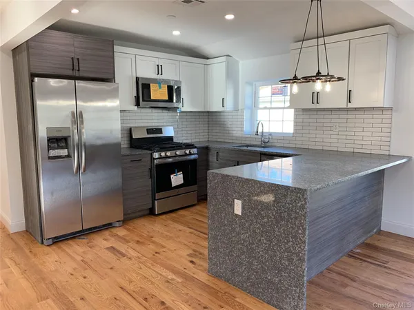 a kitchen with stainless steel appliances granite countertop a stove a refrigerator and a sink