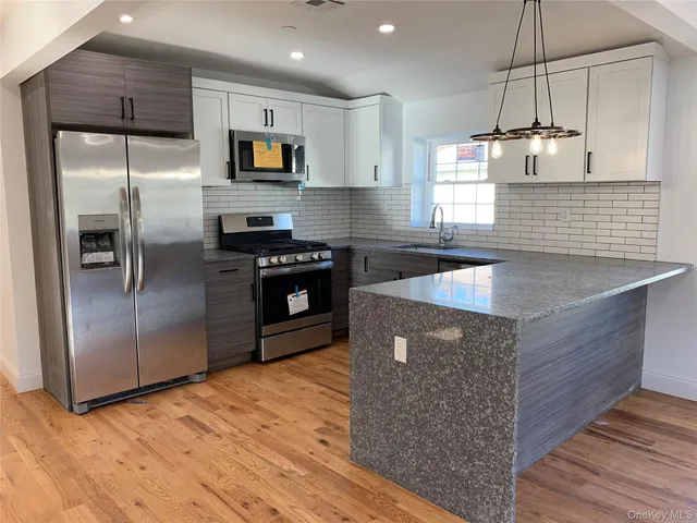 a kitchen with stainless steel appliances granite countertop a stove a refrigerator and a sink