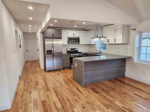 a kitchen with stainless steel appliances granite countertop a stove and a refrigerator