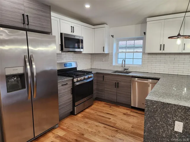 a kitchen with stainless steel appliances granite countertop a stove a sink and a refrigerator