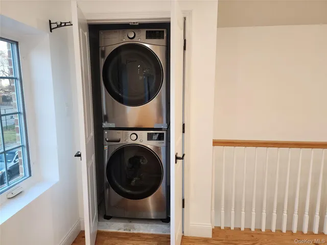 an empty room with wooden floor and large window