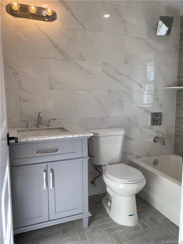 a bathroom with a double vanity sink toilet and shower