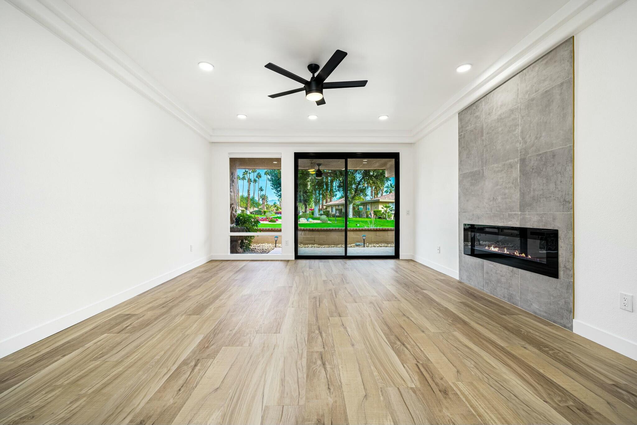 75 Sunrise Drive Rancho Mirage, CA 92270 - Photo 11 of 40 an empty room with wooden floor a ceiling fan and windows