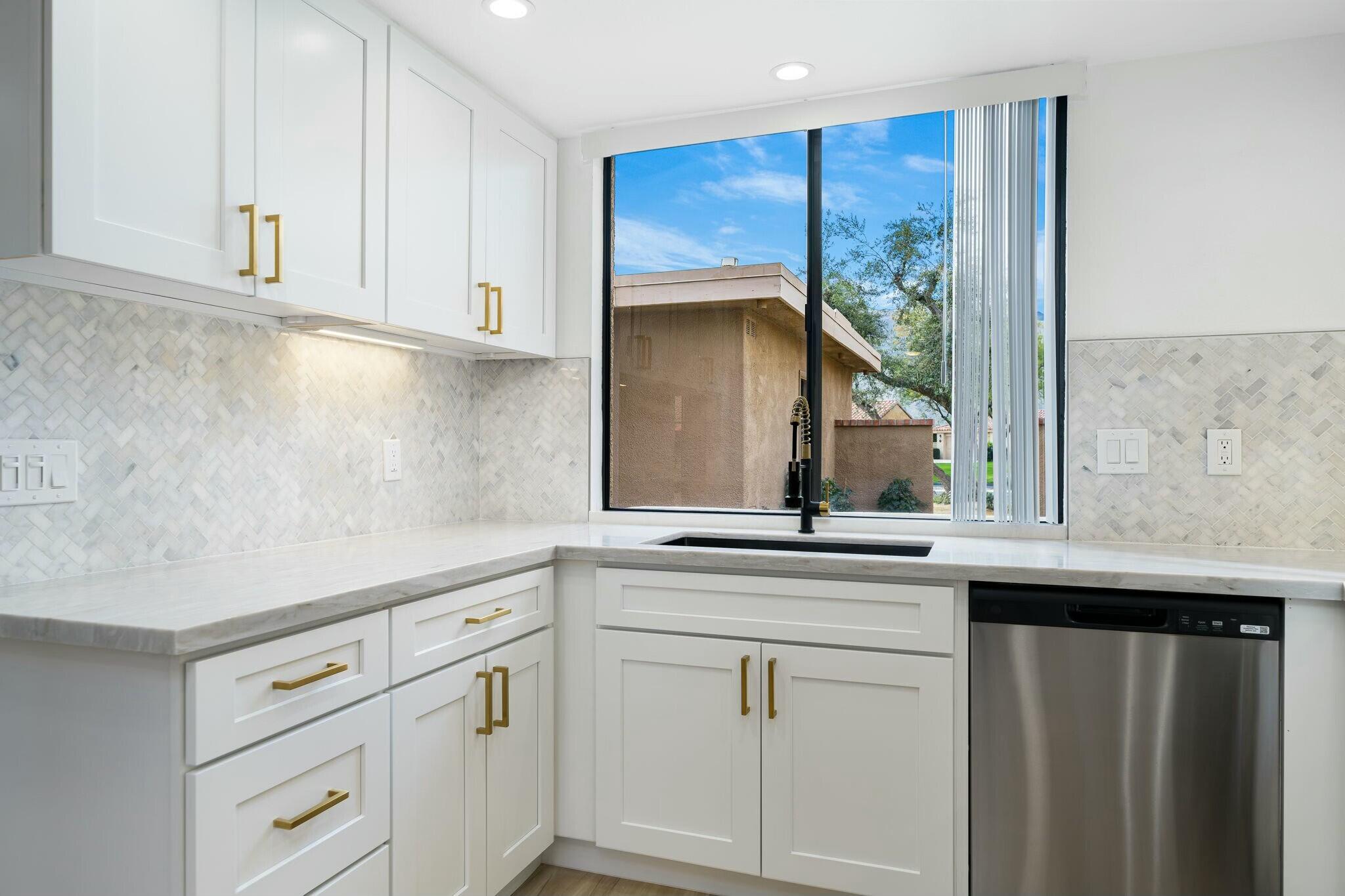 75 Sunrise Drive Rancho Mirage, CA 92270 - Photo 6 of 40 a kitchen with white cabinets and a sink