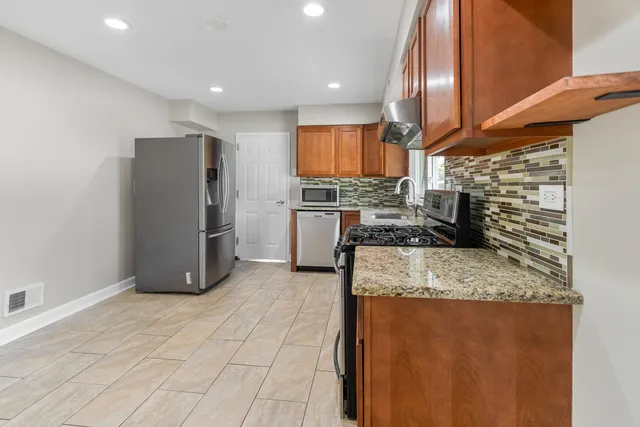 a kitchen with stainless steel appliances granite countertop a refrigerator and a stove
