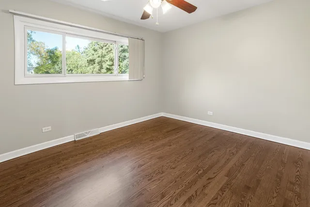 a view of a room that has wooden floor and a window