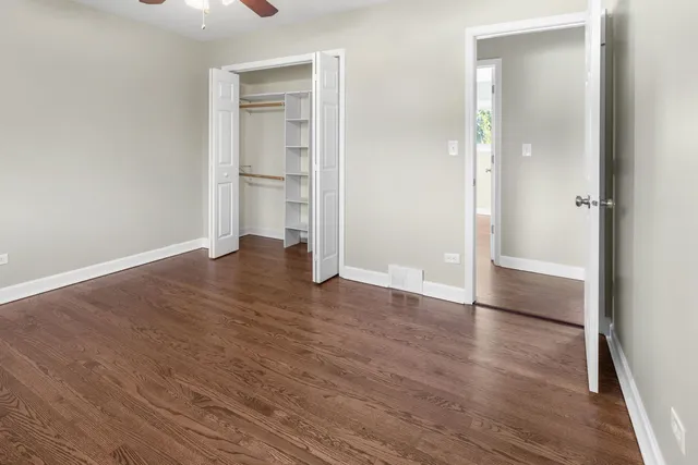 an empty room with wooden floor and entrance