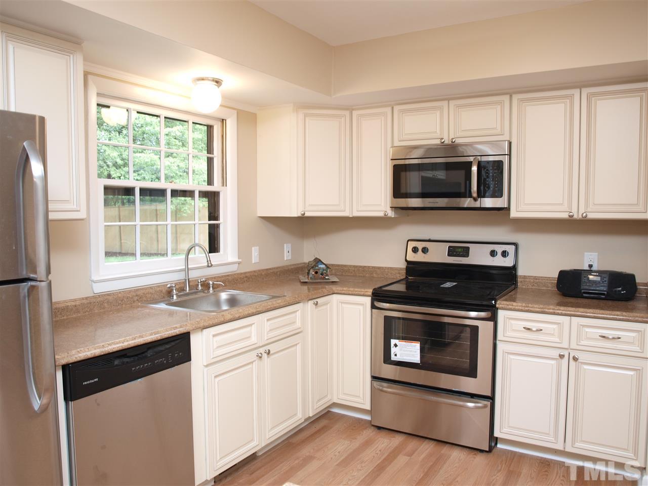7505 Ray Road Raleigh, NC 27613 - Photo 3 of 18 a kitchen with cabinets stainless steel appliances a sink and a window